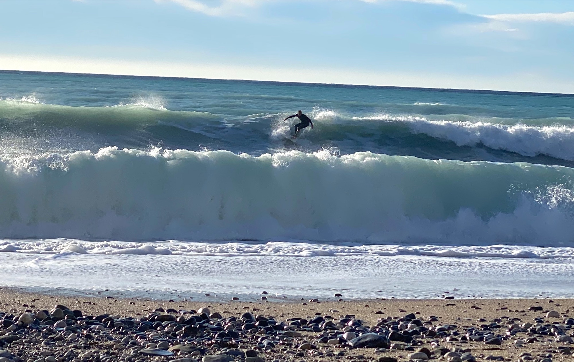 Ein einzelner Surfer in einer Welle am Mittelmeer